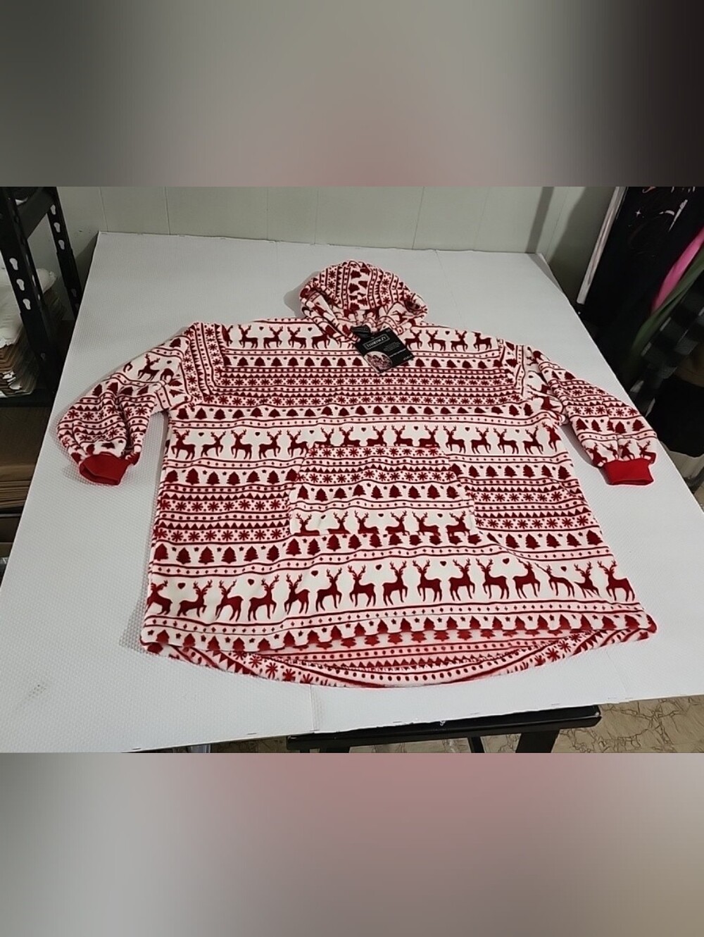 Throwzy wearable blanket hoodie features a red and white reindeer holiday patter
